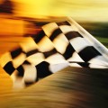 A checkered flag waving at an car race. Waving check flag in air at race finish, motion blur on flag.